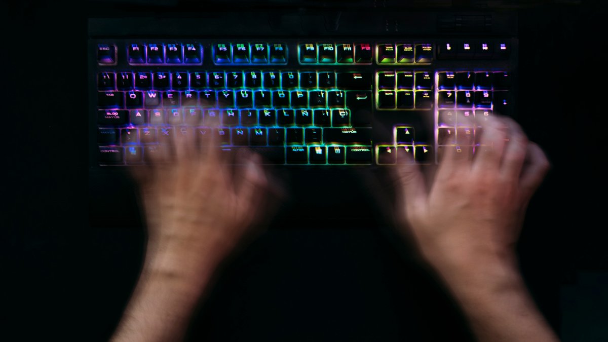 Hands at rest on a keyboard in warm light.